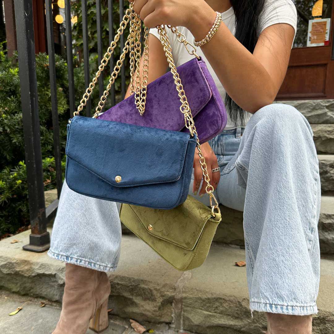 women holding multiple louise velvet handbags